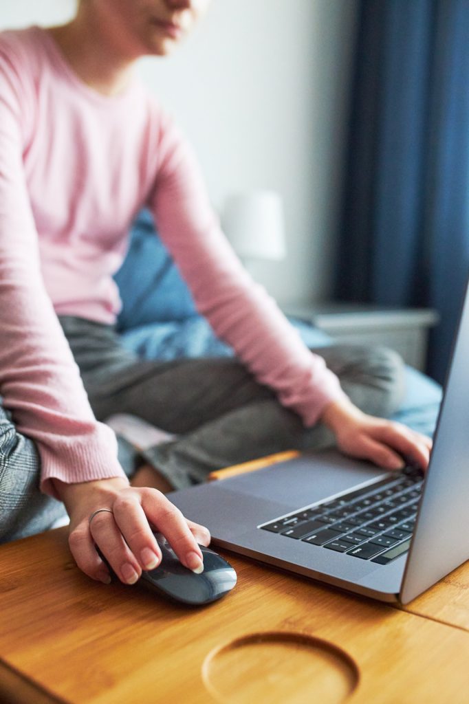 Teenage girl working on school tasks remotely on her laptop from home during COVID-19 quarantine